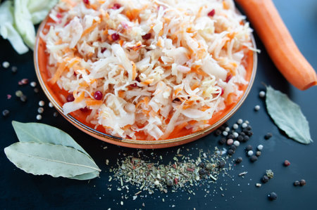 Sauerkraut on a plate surrounded by spices, black pepper and bay leaf. Top viewの写真素材