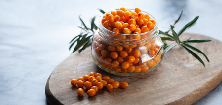 Sea buckthorn berries in a jar, orange healthy berries, macro