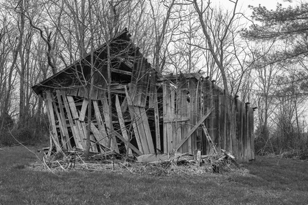 A decaying wooden barn in a rural area.の写真素材