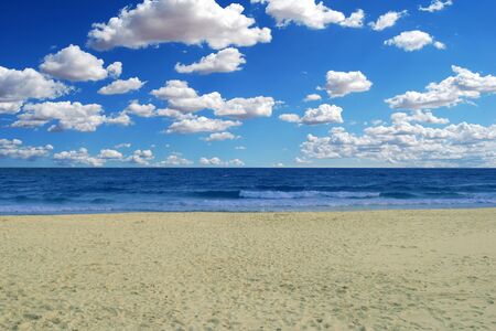 A heavenly beach under a beautiful blue sky with a few cloudsの写真素材