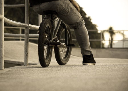 Boy resting with his bmx after practicing in the bowlの写真素材