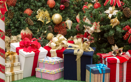 Christmas decoration with gift boxes and a big Christmas tree in the background.