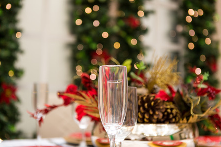 Christmas table setting for celebration at home. Glasses and stylish decoration for festive family meal.の写真素材