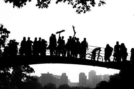 Tourists on the lake bridge of Ibirapuera Park, with skaters raising skateboard