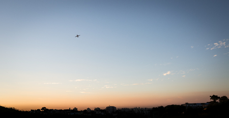 The skyline of the city of Sao Paulo with a plane taking flight from Congonhas Airport during a beautiful sunset.の写真素材