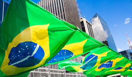 Flags of Brazil fluttering in the wind at a popular demonstration on Avenida Paulista, Sao Paulo, Brazil.の写真素材
