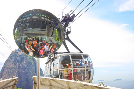 Rio de Janeiro, Brazil. January 19, 2008. Tourists in the Sugar Loaf cable car and others in the reflection of the mirror waiting for boarding.のeditorial素材