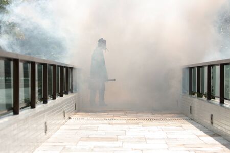 Man pesting gardens to fight the Dengue and Yellow fever mosquito in Brazil. Bug fumigation.の写真素材
