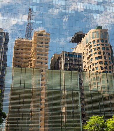 Corporate buildings on Avenida Paulista with their glass cladding making a beautiful reflection of the other buildings with trees around them.の写真素材