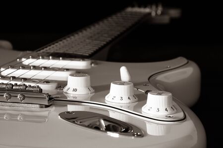 Electric guitar detail on a black background.
