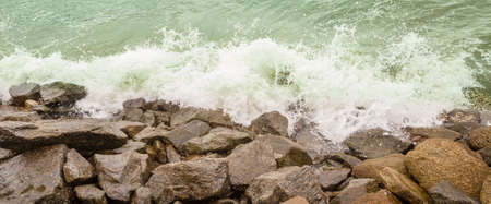 Waves crashing on rocks off the coast of the sea to try to contain the surf