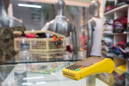 Interior of a clothing store with the credit card machine in the foreground.の写真素材