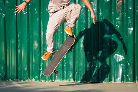 Skateboarder practicing tricks with the shadow projected on the wall.の写真素材