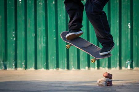 Skateboarder jumping obstacles made of bricks and stones.
