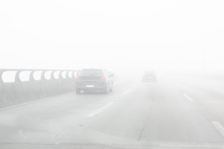 Car driving on a road on a very foggy day,