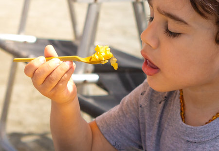 4 year old boy eating boiled corn.