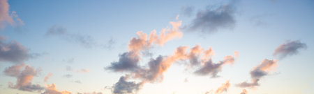 Pastel-colored clouds floating in a bright, minimal sky. Clean and airy background suitable for design, branding, and creative projects.の写真素材