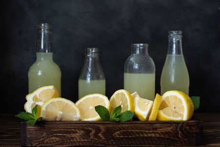 bottles with lemonade and ripe cut lemonsの写真素材