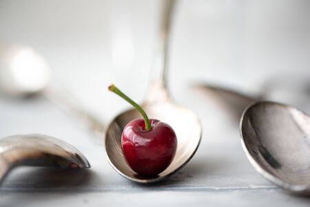 ripe large black cherries in a spoonの写真素材