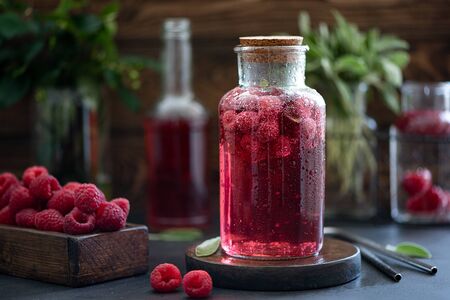 iced raspberry lemonade with sage and mint on a wooden tableの写真素材