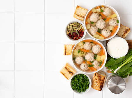potato soup with meatballs, carrots and herbs in bowlの写真素材