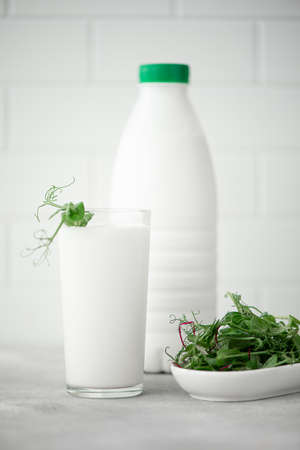 fresh kefir in a plastic bottle and glass with microgreensの写真素材