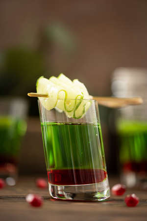 alcoholic shot with vodka and pomegranate syrup in small glassの写真素材