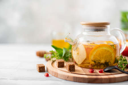 fruit tea with orange and apple in a glass teapotの写真素材