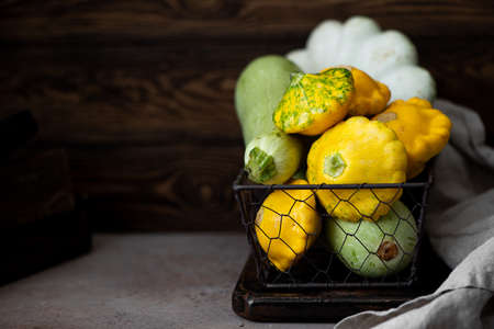 different types of squash in a wicker basket, on dark backgroundの写真素材