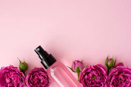pink skin tonic in a plastic bottle with rose flowersの写真素材