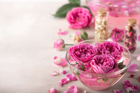 rose water in a glass bowl with petals and fresh flowers