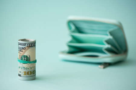 open turquoise wallet and money in the foreground
