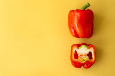 large ripe red bell pepper on yellow backgroundの写真素材