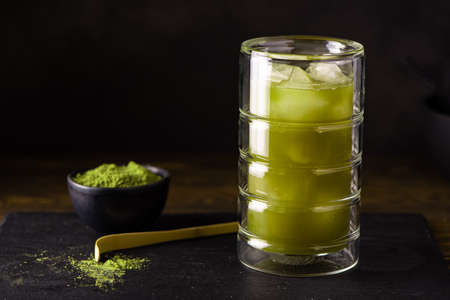 iced matcha green tea with ice in tall glass