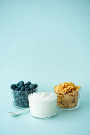 cornflakes with greek yogurt milk and berries on a blue backgroundの写真素材