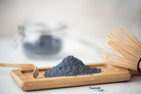blue matcha powder on wooden board on a white table