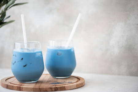 iced blue matcha tea with milk in glass on a wooden boardの写真素材