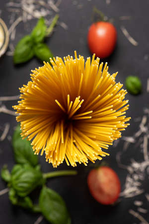 Spaghetti with basil and tomatoes on a black background, top viewの写真素材