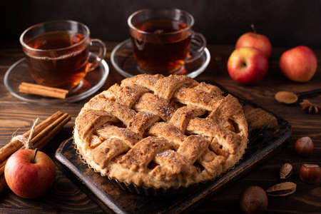 apple pie with cinnamon and hot black tea on a wooden tableの写真素材