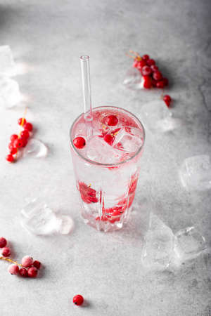 mineral sparkling water with ice and red currants in a glassの写真素材
