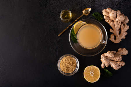 hot vitamin drink made from ground ginger, lemon and honey on a black table, top viewの写真素材