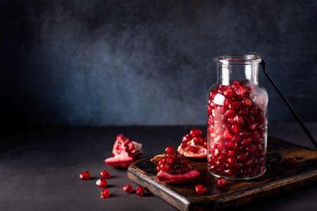 peeled ripe pomegranate seeds in a glass bottle, close-upの写真素材