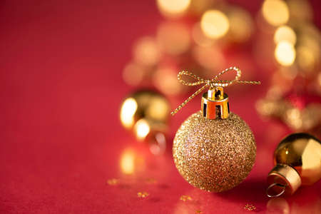 Christmas tree ball of golden color, close-up on a red background