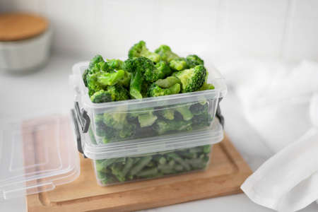 frozen broccoli florets in a plastic container, close-upの写真素材