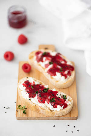 two sandwiches with raspberry jam and curd cheese, close-up