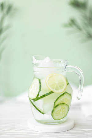 mineral water with cucumber and lemon in a glass jug, close-upの写真素材