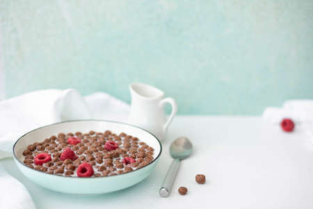chocolate corn flakes with milk and raspberries, close-upの写真素材