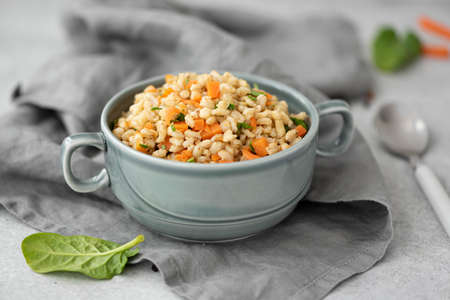 boiled barley porridge with vegetables in a gray plate, close-upの写真素材