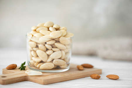 peeled large almonds in a glass bowl, close-upの写真素材