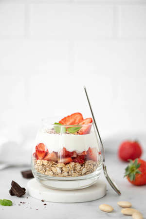 oatmeal with greek yogurt and fresh strawberries in a glass, close-upの写真素材